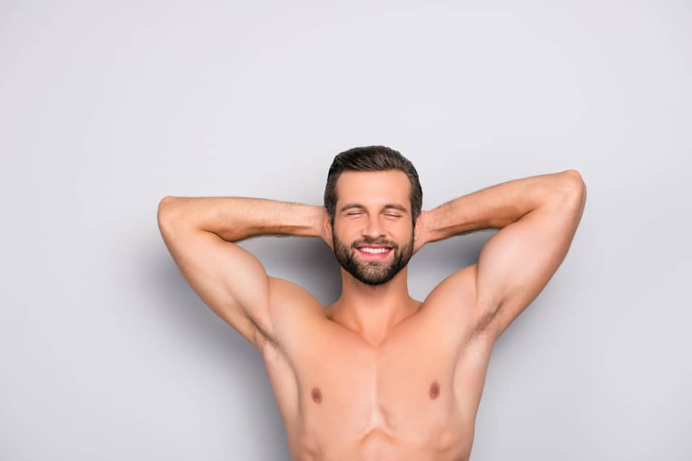 Man happy with a well defined masculine chest after gynecomastia surgery.