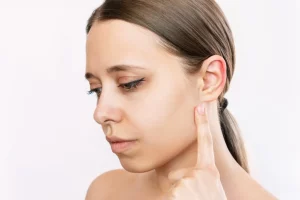 Scarring is minimal and usually hidden behind the ear; proper wound care and avoiding sun exposure can help the scars heal better.