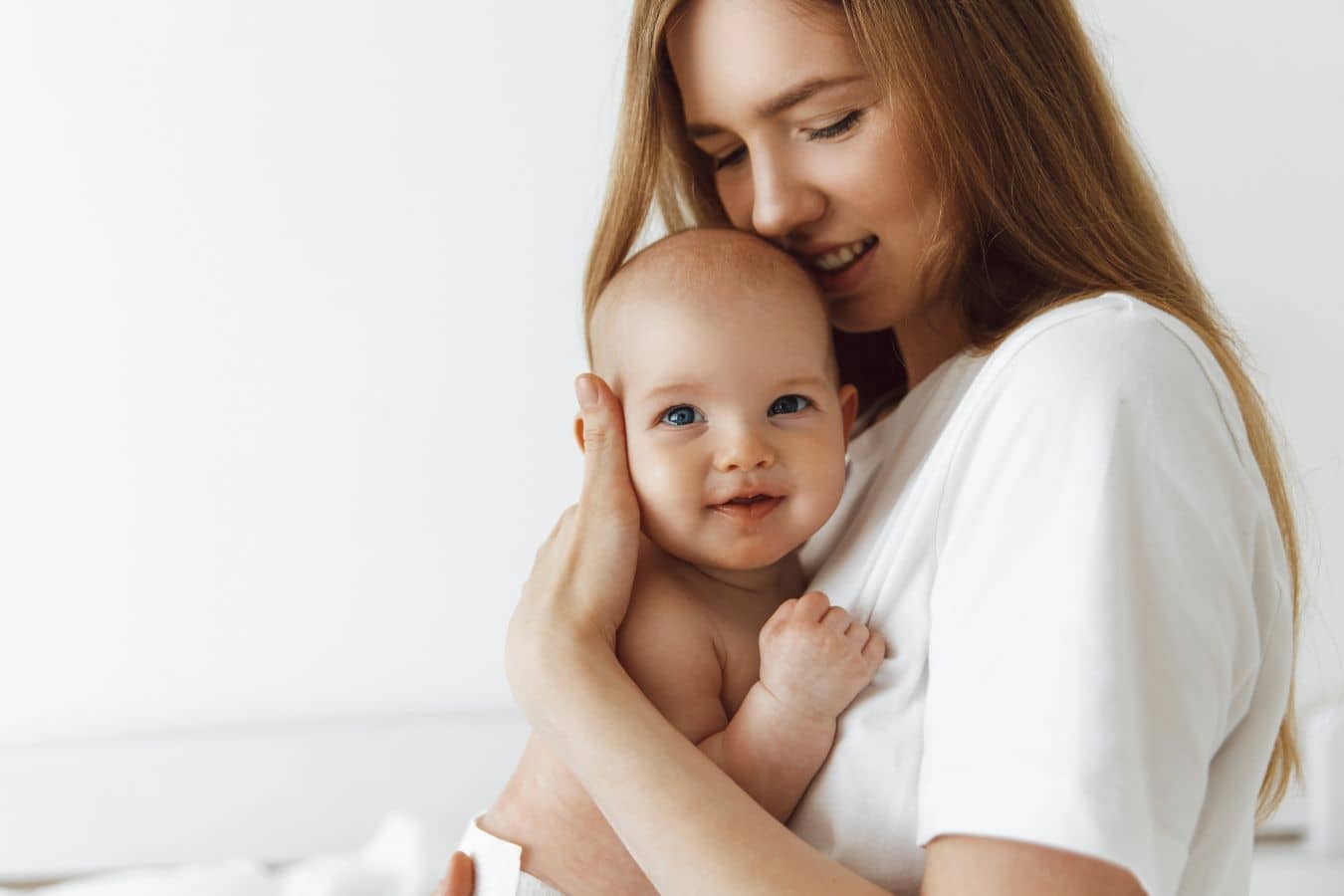 Mother holding baby while discussing breastfeeding after breast augmentation and how implants may affect nursing.