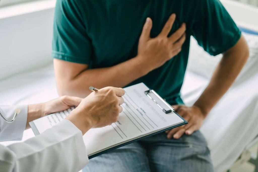 Doctor discussing non-surgical gynecomastia options with a man concerned about chest fullness during consultation
