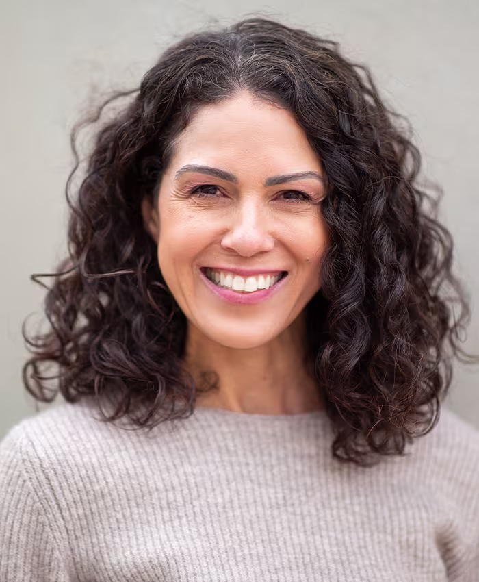 Smiling woman with healthy-looking skin, representing candidates for PRP with microneedling in Naples, FL.